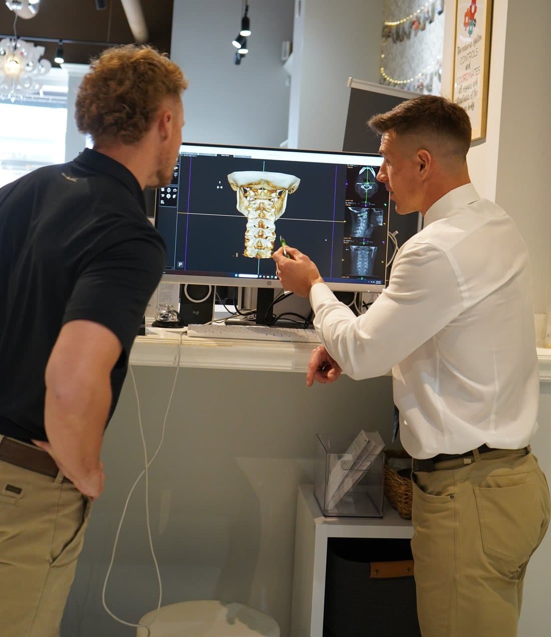 Dr. Tim reviewing a patient’s 3D upper cervical scan with them at Limitless Chiropractic